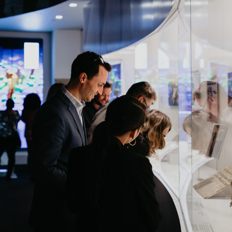 An image of adults viewing an exhibit at a history museum.